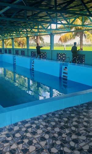 Large blue swimming pool equipped with three wall-mounted plug and play filtration units under a covered canopy.