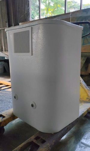 Side perspective view of a white plug and play pool filtration box on a pallet jack showing side wall and outlet nozzles.